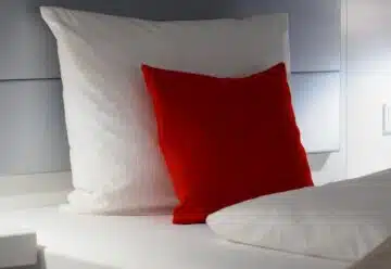lit avec un oreiller blanc et un oreiller rouge