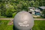 white and gray round water tank on green grass field during daytime