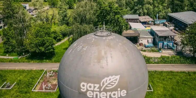 white and gray round water tank on green grass field during daytime